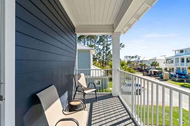 a balcony view with a large window and outdoor seating