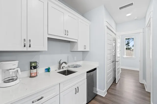a kitchen with white cabinets and sink