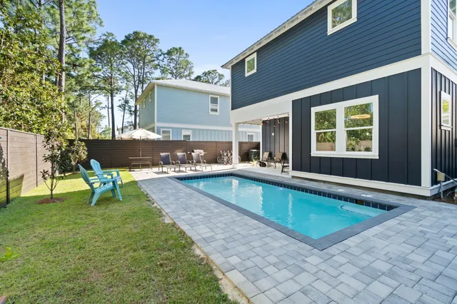 a swimming pool with outdoor seating and yard