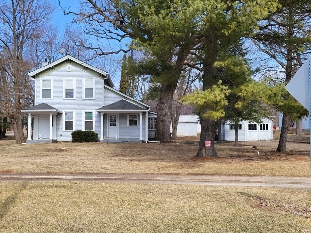 a view of a house with a yard and large tree