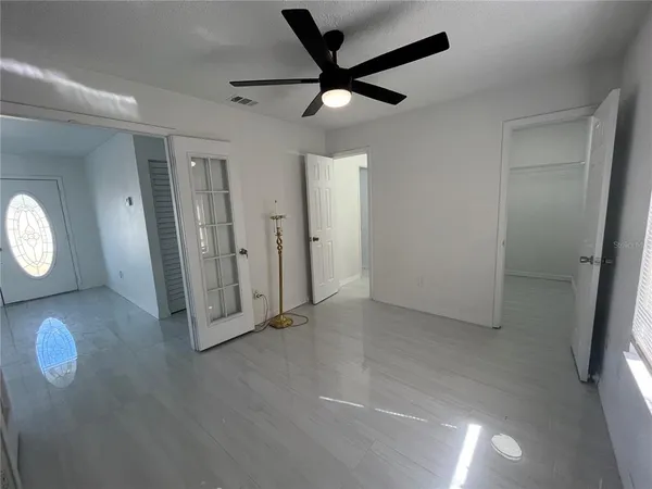 an empty room with wooden floor and windows