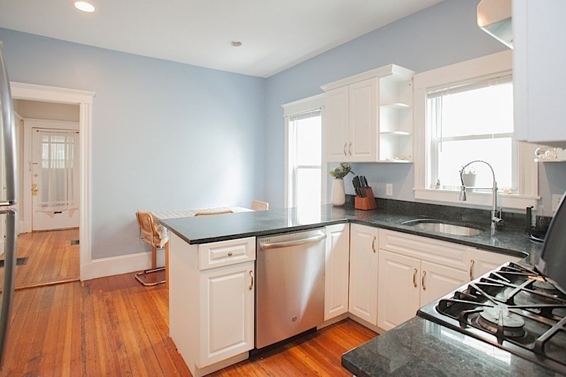 50 Holyoke Road, Unit 1 Somerville, MA 02144 - Photo 2 of 14 a kitchen with granite countertop a sink stove and cabinets