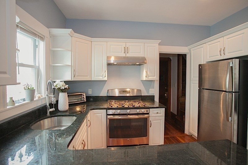 50 Holyoke Road, Unit 1 Somerville, MA 02144 - Photo 3 of 14 a kitchen with granite countertop a stove refrigerator and microwave