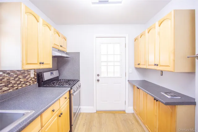 a kitchen with granite countertop a sink and a refrigerator