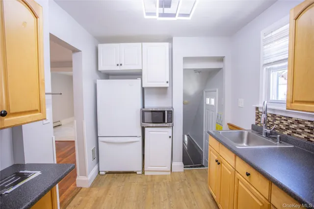 a kitchen with a refrigerator sink and cabinets