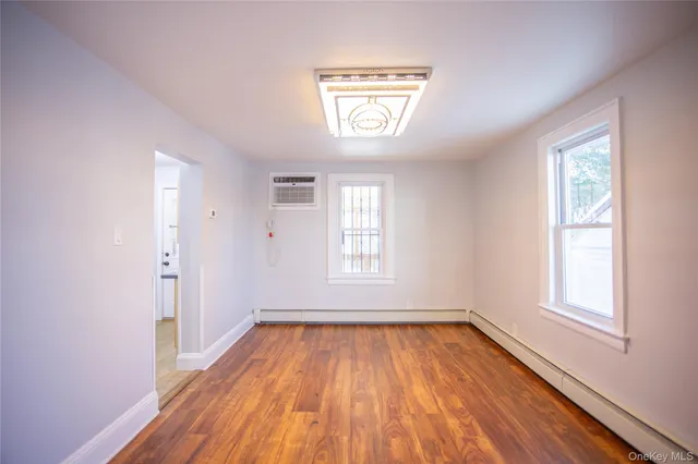 an empty room with a window and wooden floor