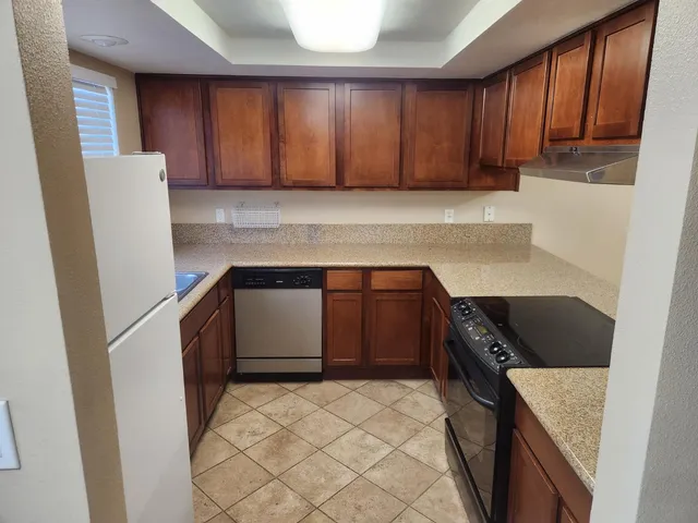 a kitchen with a refrigerator sink and cabinets