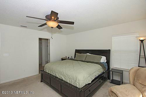 219 Crown Wheel Circle St. Johns, FL 32259 - Photo 14 of 18 a bedroom with a bed chandelier and a window