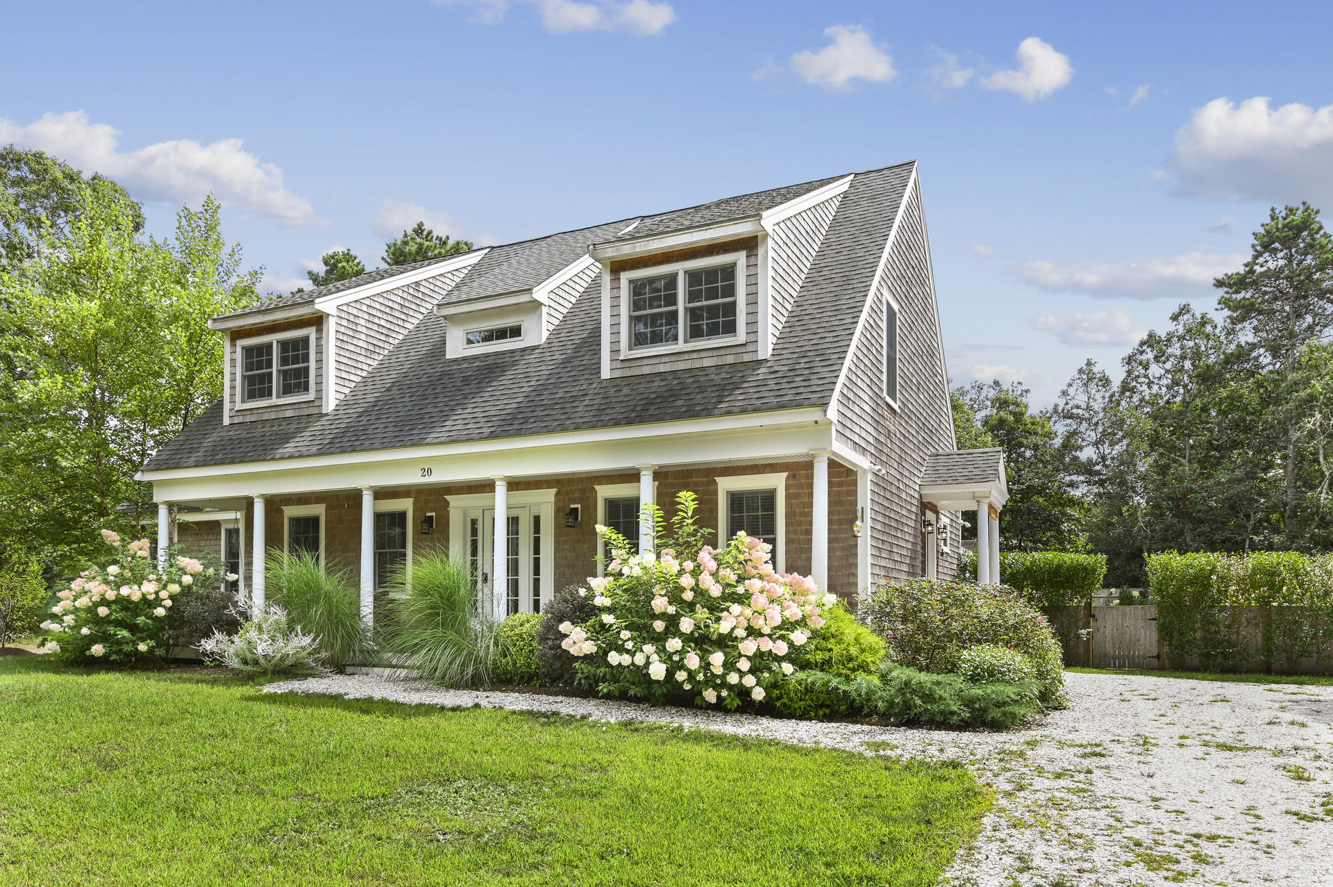 a front view of a house with a garden and plants
