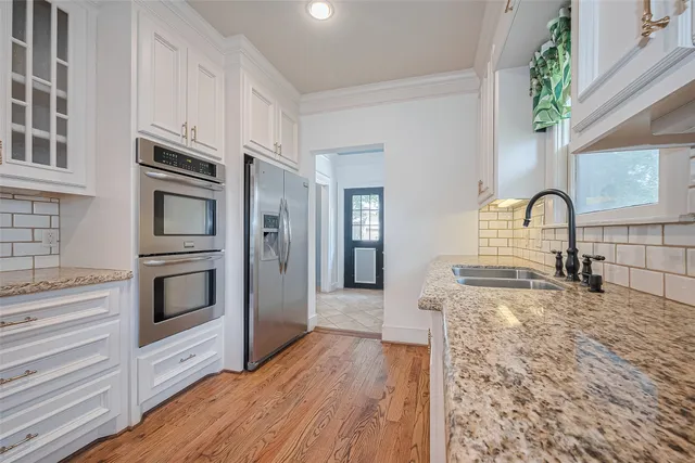 a open kitchen with kitchen island white cabinets and wooden floor