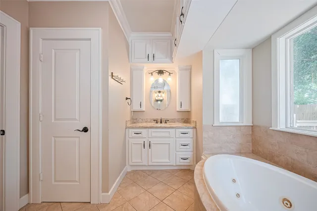 a bathroom with a tub sink and mirror