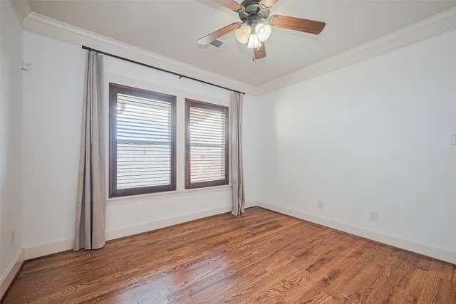 an empty room with wooden floor chandelier fan and closet area