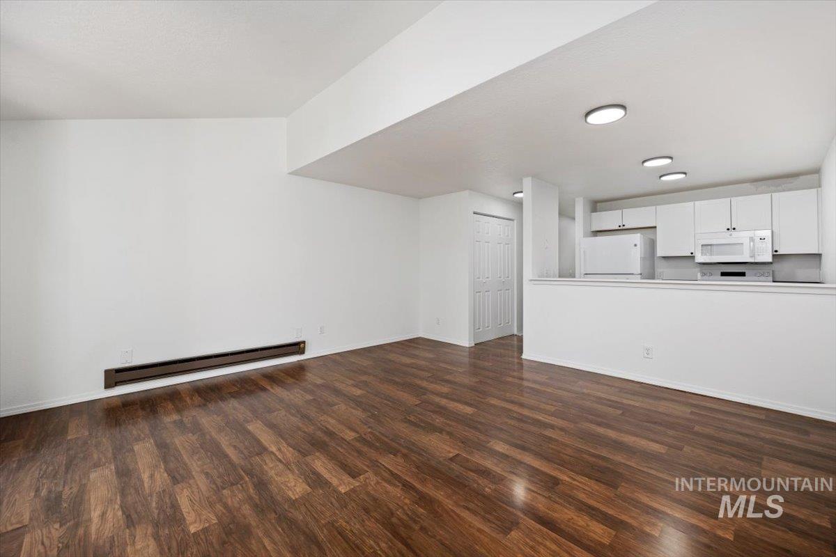 259 Pheasant Road, Unit 84 Twin Falls, ID 83301 - Photo 6 of 25 Open concept living area featuring wood-finish flooring, white walls, and a partial wall separating the kitchen