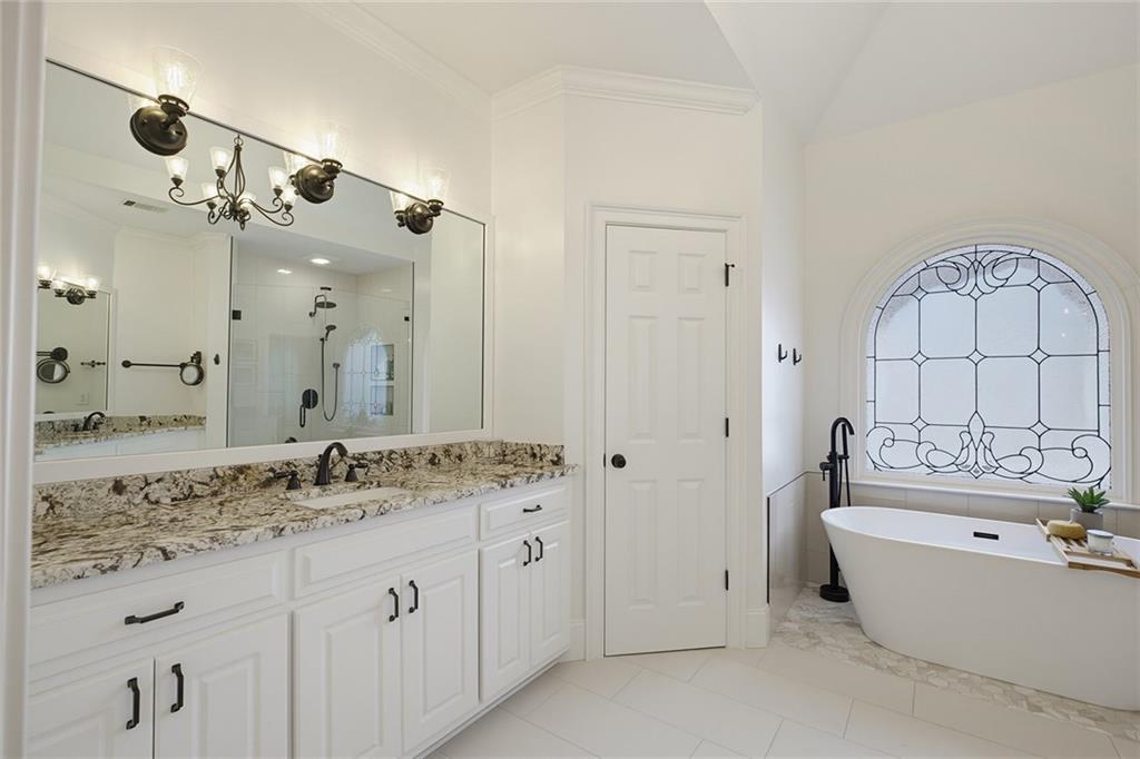14442 Club Circle Milton, GA 30004 - Photo 34 of 82 a bathroom with a tub a double vanity sink and mirror