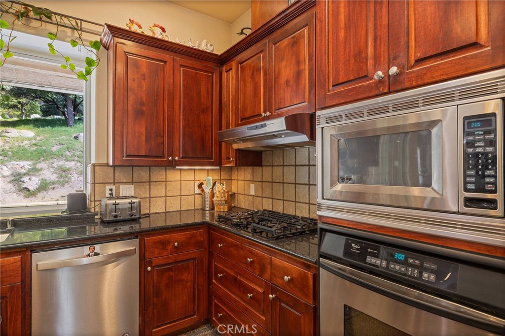 36919 Deer Path Circle Coarsegold, CA 93614 - Photo 13 of 59 a kitchen with granite countertop a sink stove and cabinets