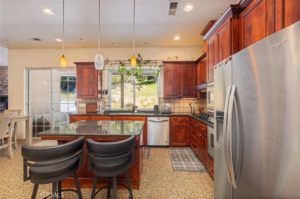 36919 Deer Path Circle Coarsegold, CA 93614 - Photo 14 of 59 a kitchen with stainless steel appliances granite countertop a refrigerator a sink a stove and a microwave