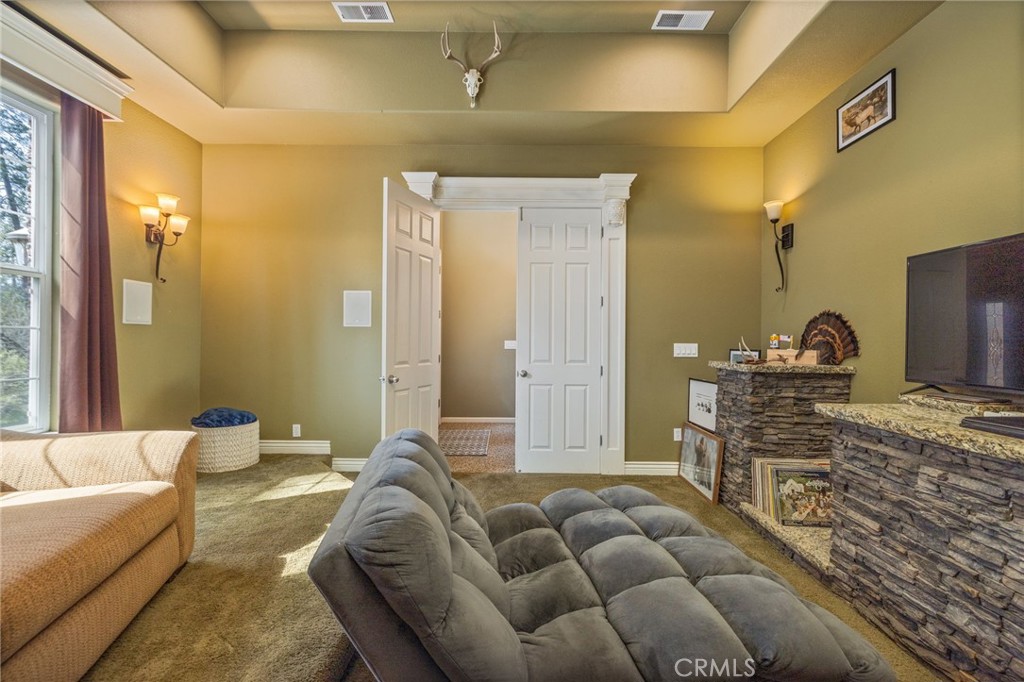 36919 Deer Path Circle Coarsegold, CA 93614 - Photo 21 of 59 a living room with furniture a mirror and a flat screen tv