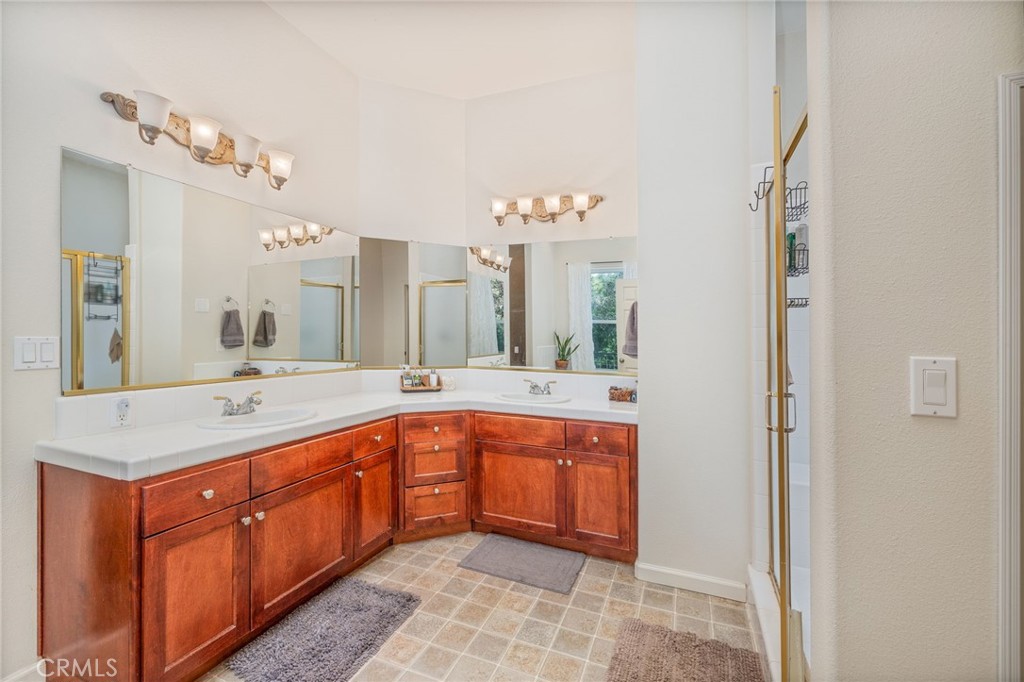 36919 Deer Path Circle Coarsegold, CA 93614 - Photo 28 of 59 a spacious bathroom with a granite countertop sink a mirror and a bathtub