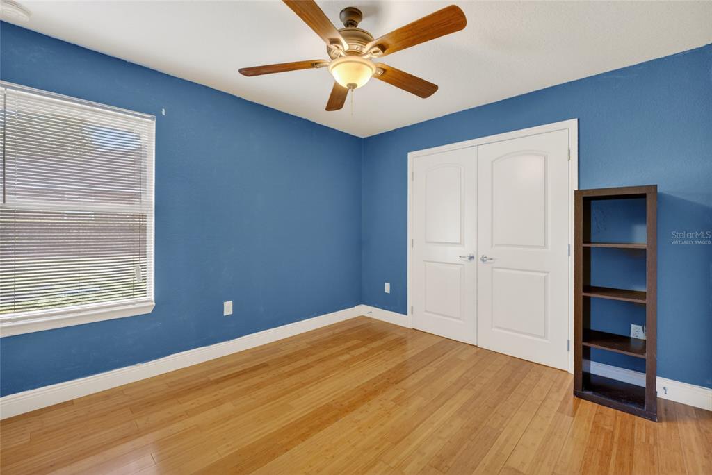 4319 Southwest 63rd Street Ocala, FL 34474 - Photo 22 of 29 a view of a room with wooden floor and a ceiling fan