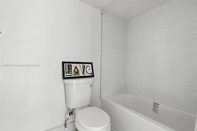 a white toilet sitting next to a bath tub