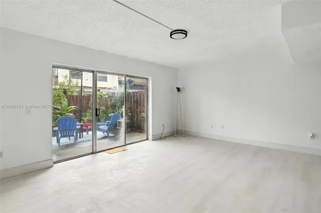 an empty room with floor to ceiling window and an outdoor view