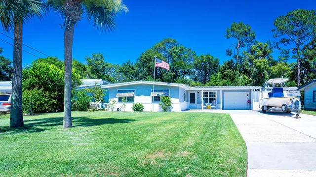 a front view of a house with a yard and trees