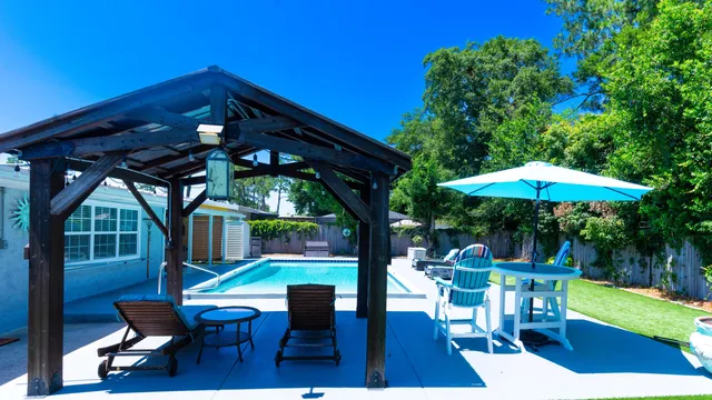 a view of a house with backyard sitting area and furniture