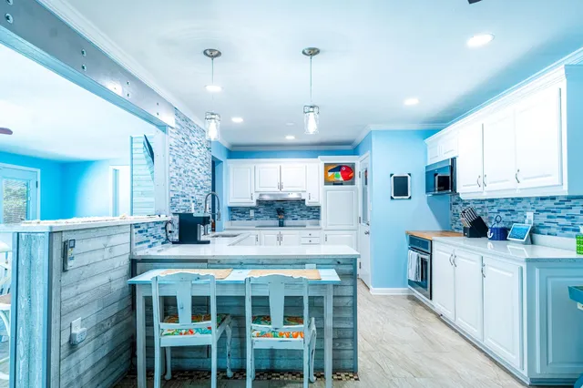 a kitchen with kitchen island granite countertop a sink and cabinets