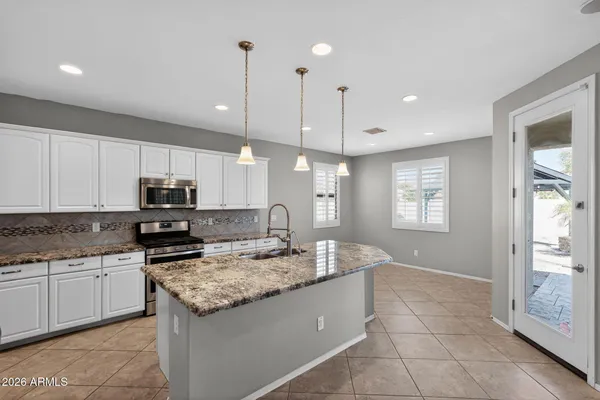 a large kitchen with lots of counter space and stainless steel appliances