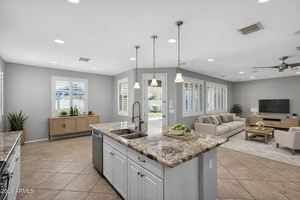 an empty room with chandelier fan and windows