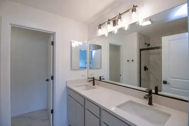 a bathroom with a sink a light fixture and a mirror