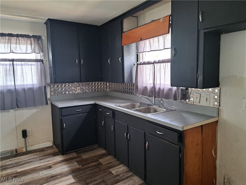 2239 North Ridge Road Lorain, OH 44055 - Photo 12 of 28 Kitchen featuring dark wood finished floors, light countertops, and decorative backsplash