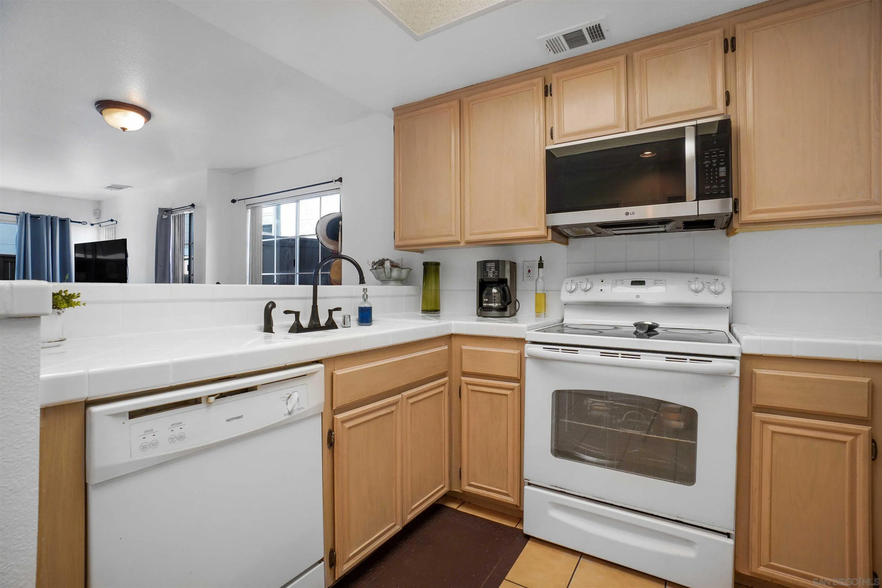 8966 Arlingdale Way Spring Valley, CA 91977 - Photo 2 of 24 a kitchen with a sink stove and microwave