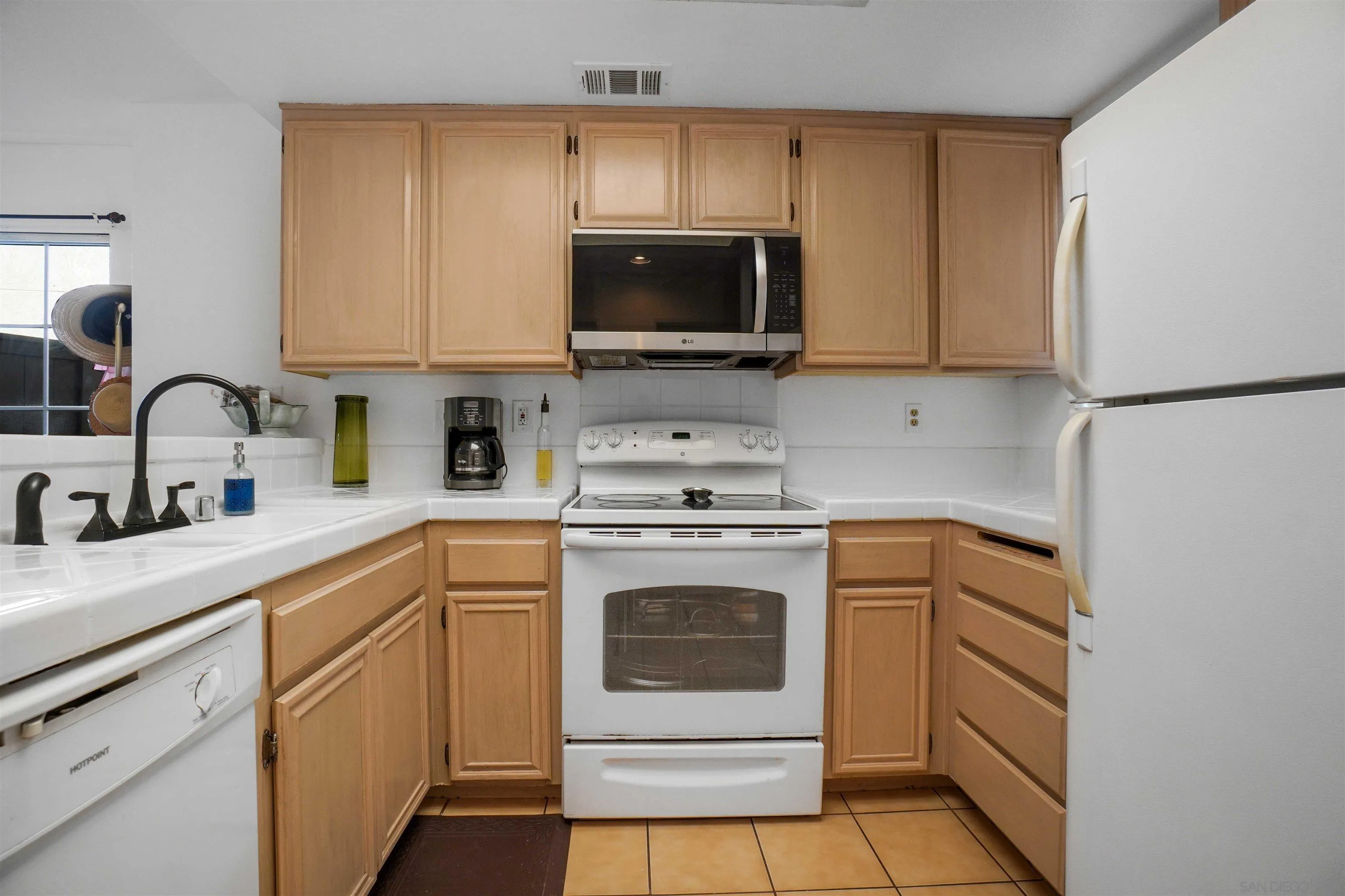 8966 Arlingdale Way Spring Valley, CA 91977 - Photo 3 of 24 a kitchen with a sink stove and microwave