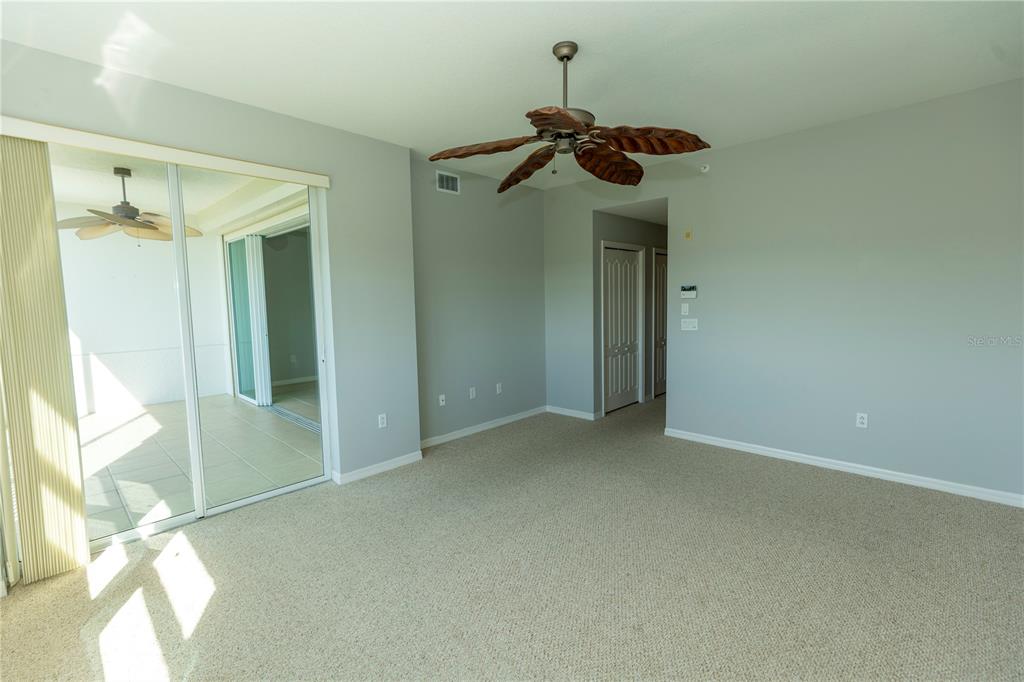 9203 Griggs Road, Unit B102 Englewood, FL 34224 - Photo 20 of 66 a view of a room with a chandelier fan and windows
