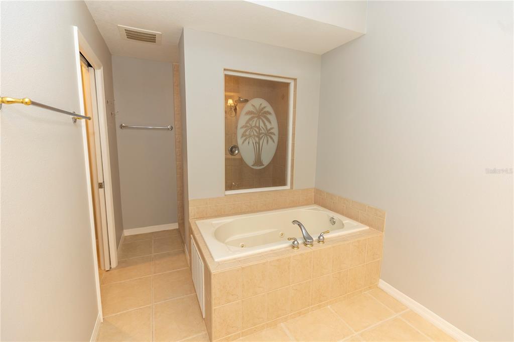 9203 Griggs Road, Unit B102 Englewood, FL 34224 - Photo 23 of 66 a bathroom with a tub and shower