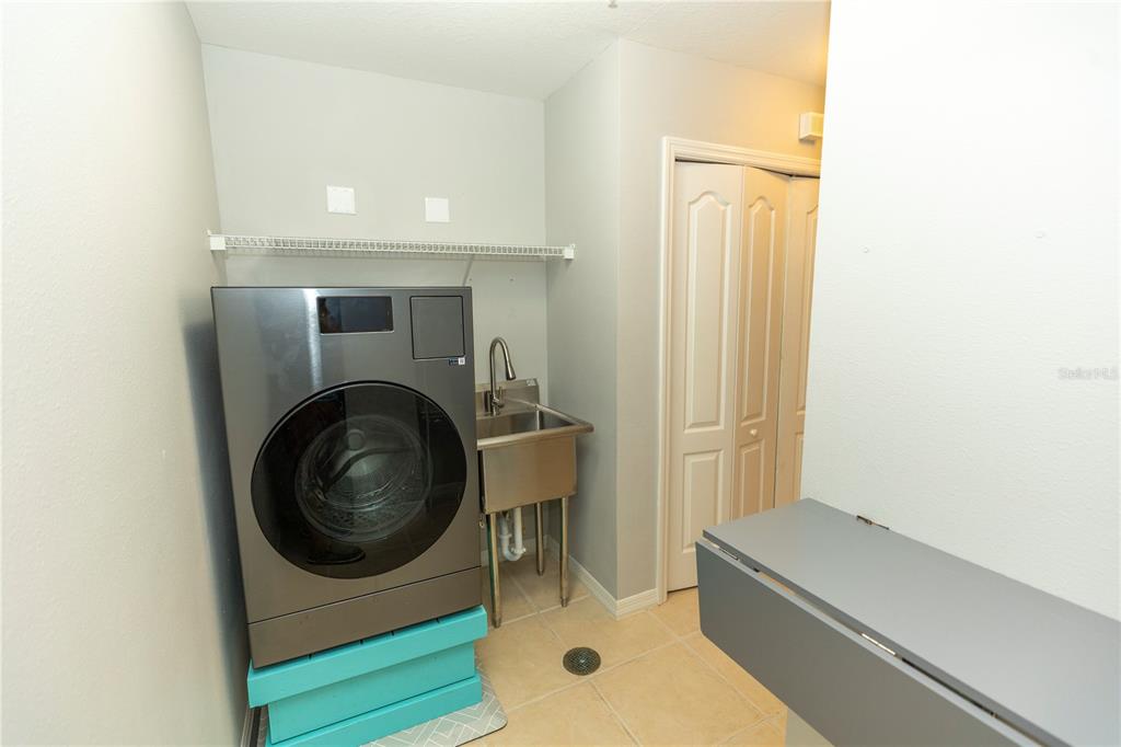 9203 Griggs Road, Unit B102 Englewood, FL 34224 - Photo 29 of 66 a living room with a washer and dryer