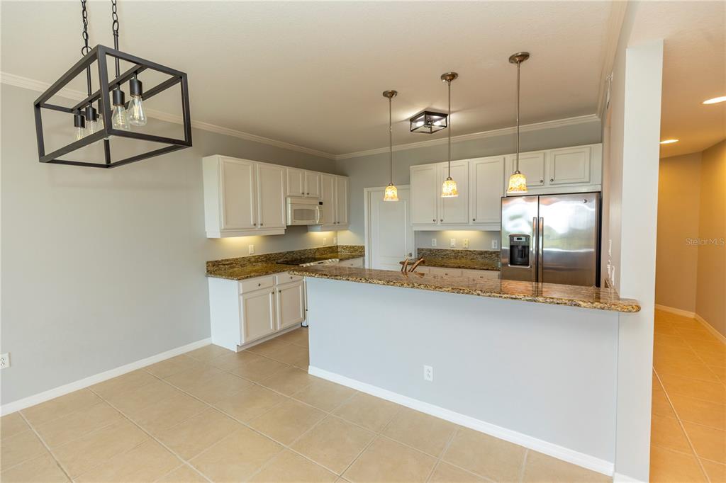 9203 Griggs Road, Unit B102 Englewood, FL 34224 - Photo 10 of 66 a large kitchen with cabinets and wooden floor