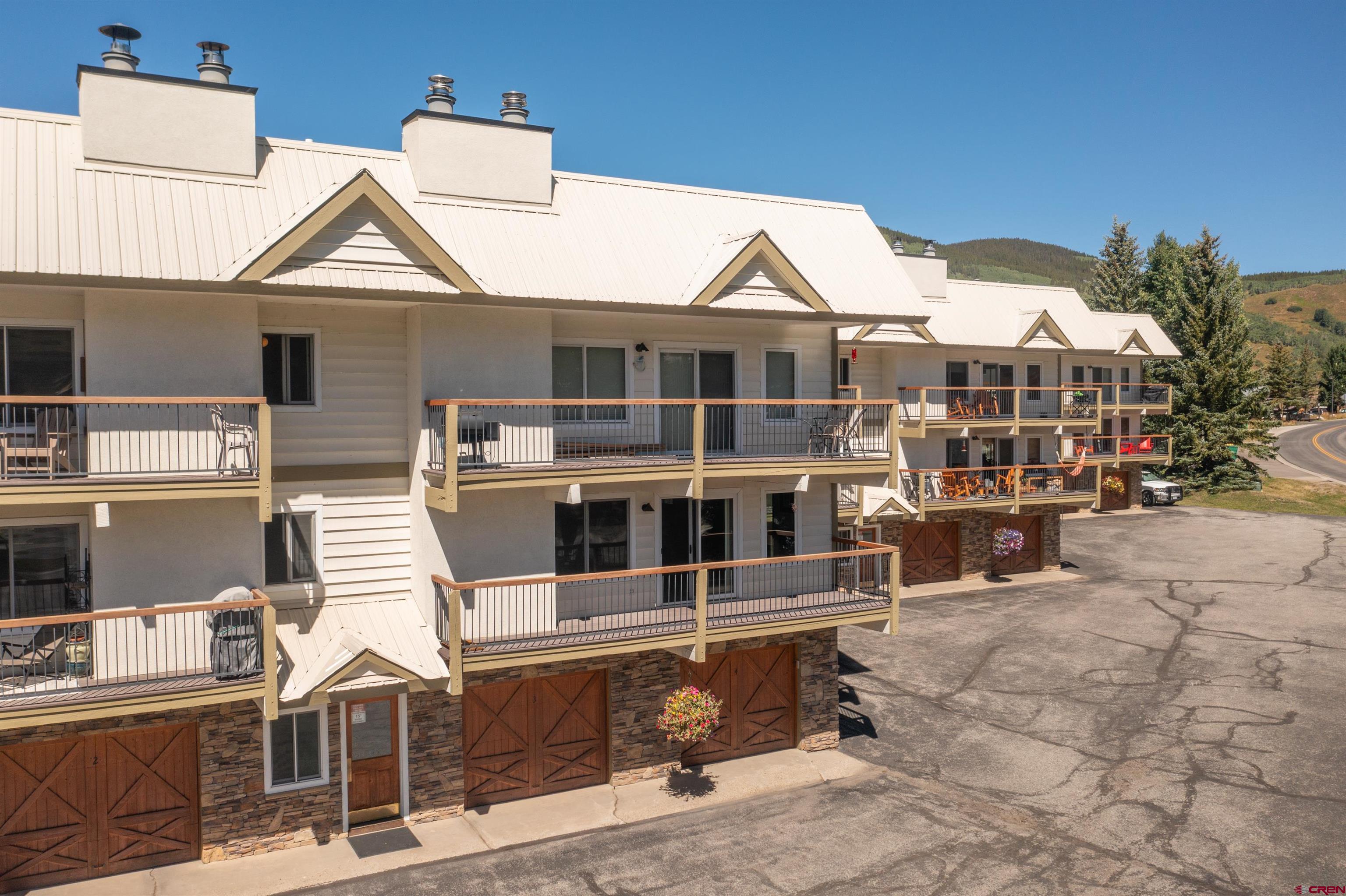 721 Gothic Road, Unit C3 Crested Butte, CO 81225 - Photo 26 of 33 a view of a white house with large windows and a table and chairs