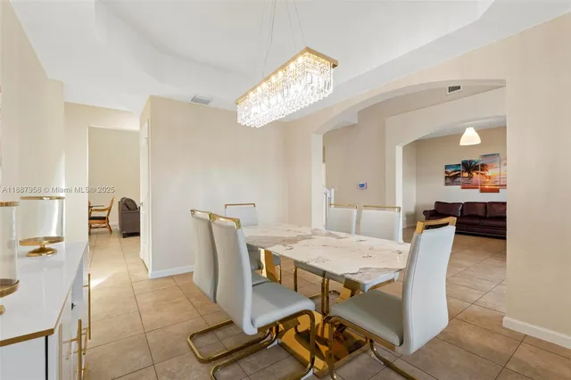 a view of a dining room with furniture and a chandelier