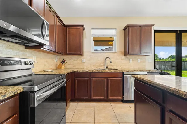 a kitchen with a sink stove top oven and microwave