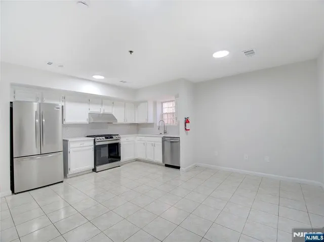 a kitchen with white cabinets and stainless steel appliances