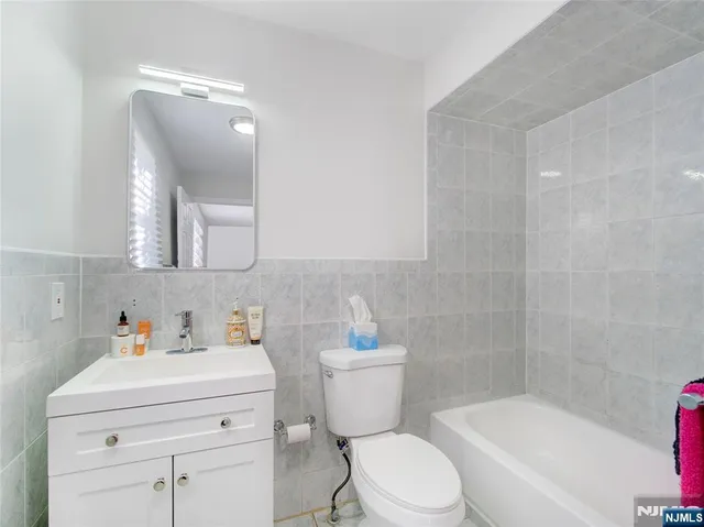 a bathroom with a sink toilet vanity and bathtub