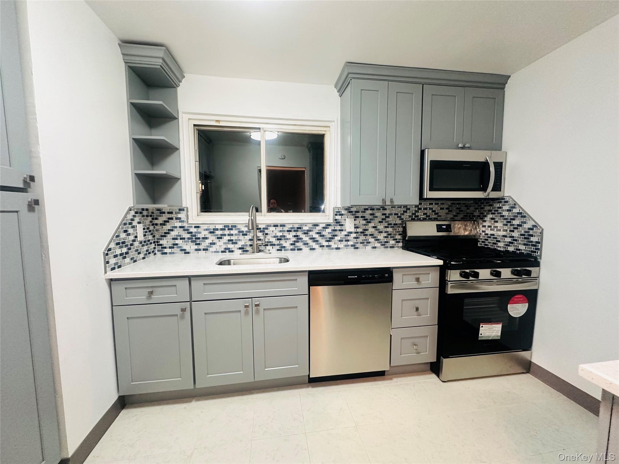 1003 Rottkamp Street, Unit 1 Valley Stream, NY 11580 - Photo 13 of 16 a kitchen with a sink and stove top oven