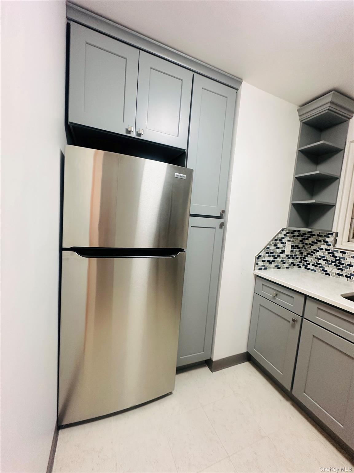 1003 Rottkamp Street, Unit 1 Valley Stream, NY 11580 - Photo 14 of 16 a kitchen with a refrigerator and cabinets