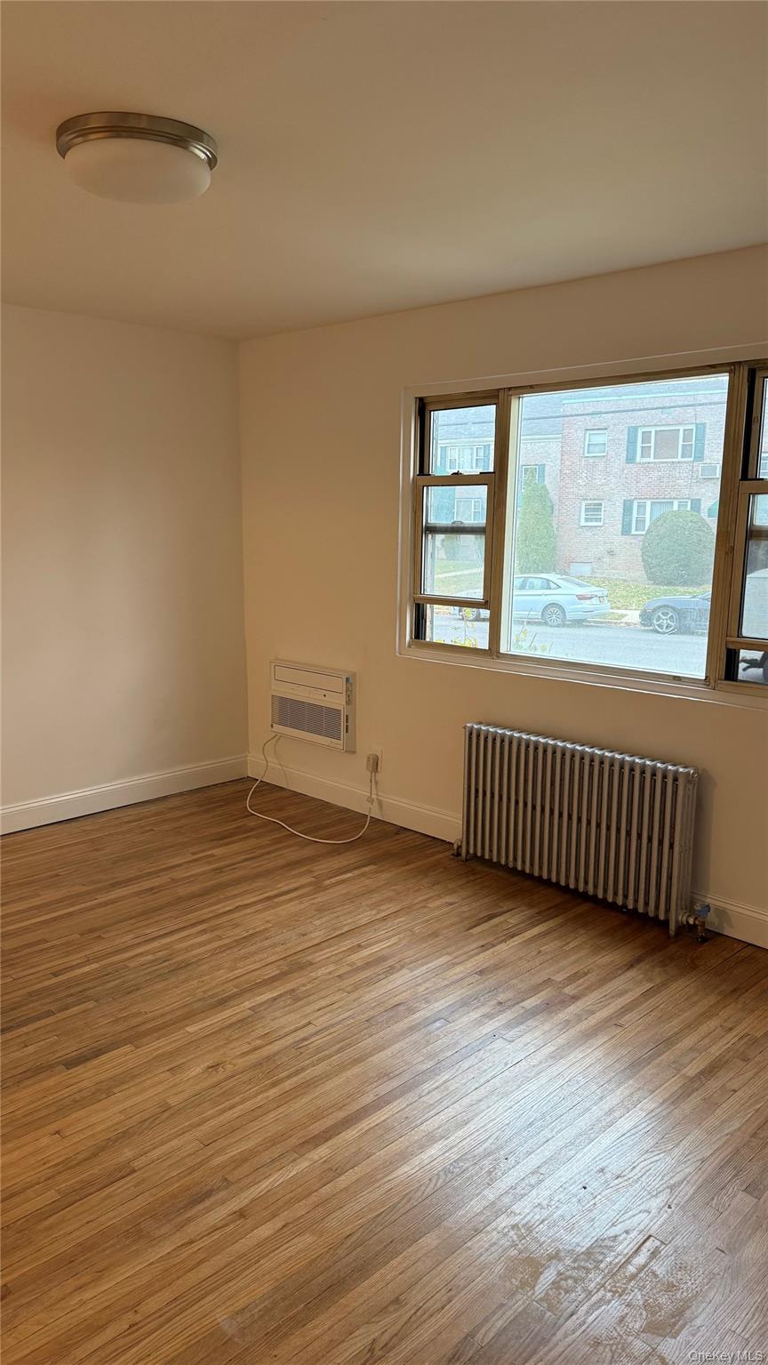 1003 Rottkamp Street, Unit 1 Valley Stream, NY 11580 - Photo 7 of 16 wooden floor in an empty room with a window
