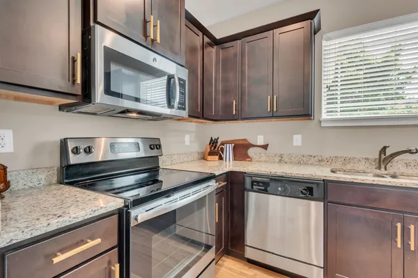 a kitchen with stainless steel appliances granite countertop a sink stove and microwave