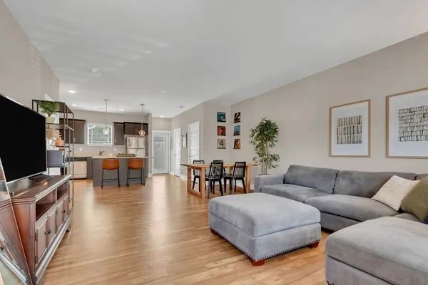 a living room with furniture and a flat screen tv with wooden floor