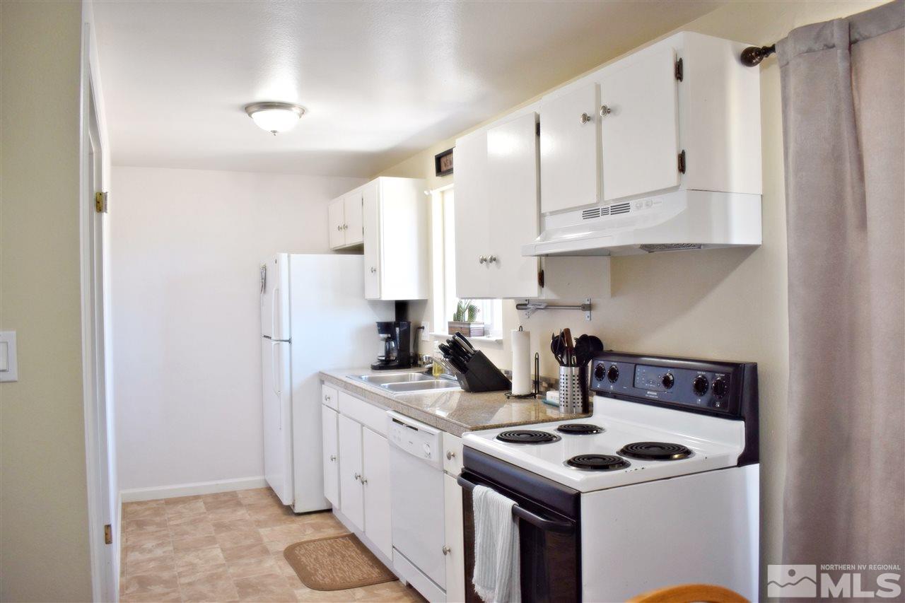 9185 Fremont Way Reno, NV 89506 - Photo 3 of 10 a kitchen with stainless steel appliances granite countertop a stove a refrigerator and a white cabinets
