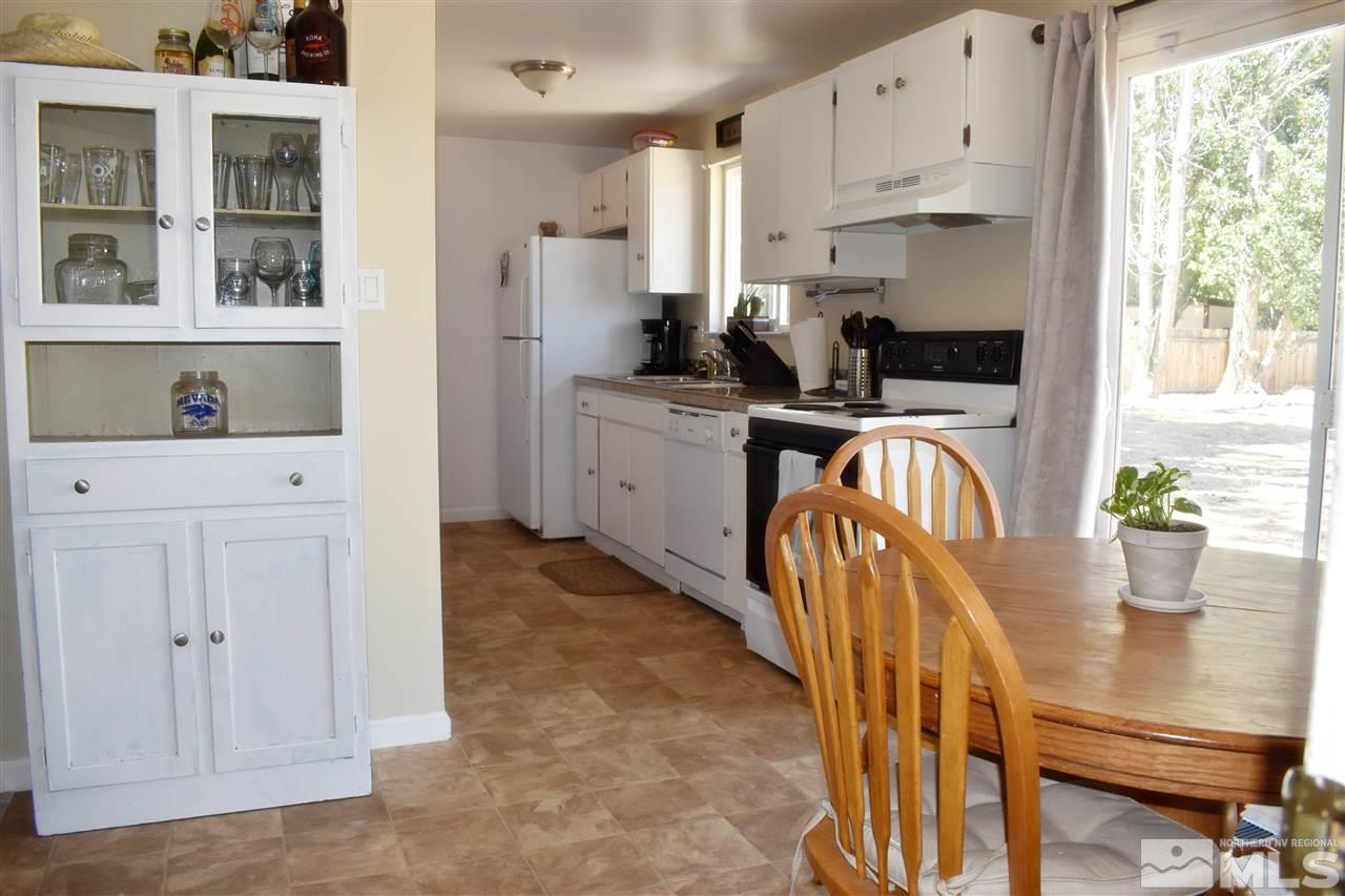 9185 Fremont Way Reno, NV 89506 - Photo 4 of 10 a kitchen with stainless steel appliances granite countertop a refrigerator a stove a sink dishwasher and white cabinets with wooden floor